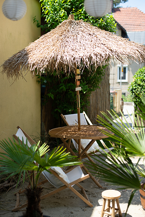 Sitzecke im Bali-Stil vor dem THE Bridal SPA mit Palmen und Naturmaterialien
