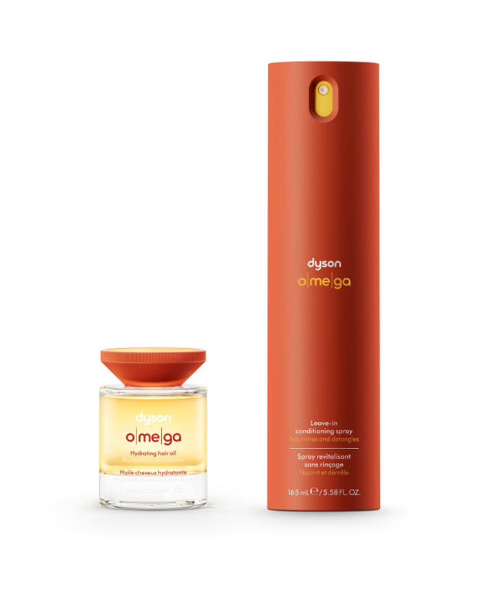 Produktfotografie der Dyson Omega Haarpflegeserie. Ein Orangerotes Spray, sowie ein Haaröl mit orangerotem Deckel auf weissem Hintergrund